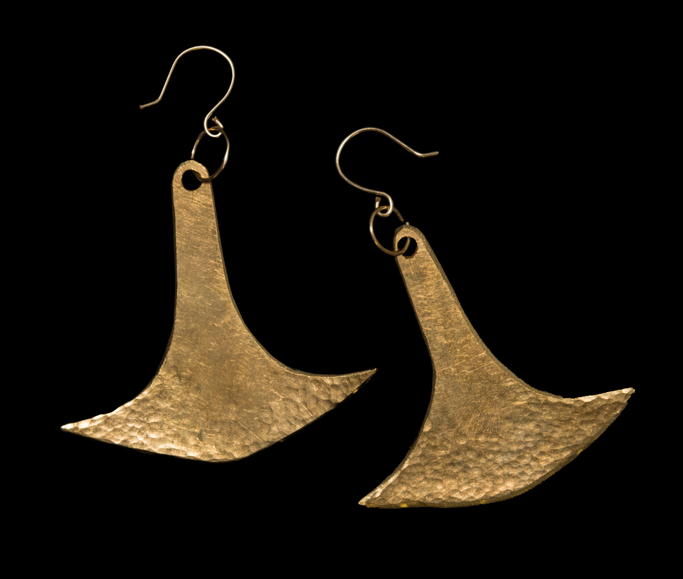 two gold colored earrings. They are similar to the shape of an anchor and have a hammered detail near the bottom