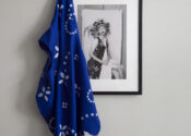 a black and white photograph hung against a wall with a blue garment draped on it