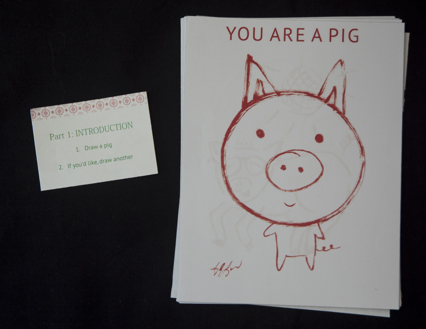 a drawing of a pig and a piece of paper that states "1. draw a pig 2 if you'd like, draw another"