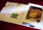 various printed images, drawings, and photographs lay on a red velvet with light streaking over it