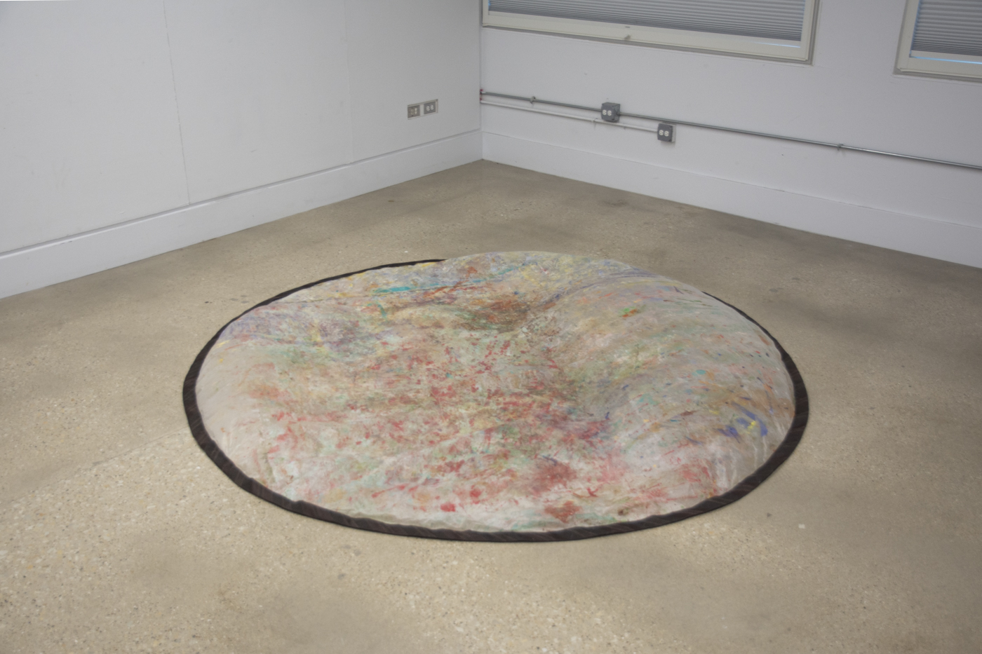 a colorful rainbow circle sits in the middle of a room.