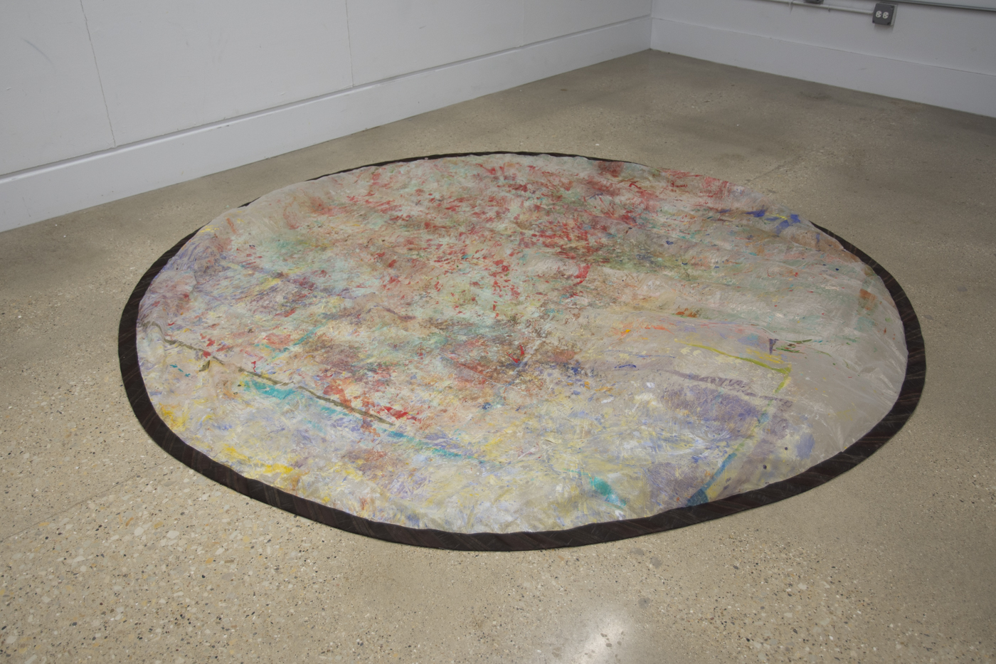 A colorful rainbow circle sits in the middle of a room.