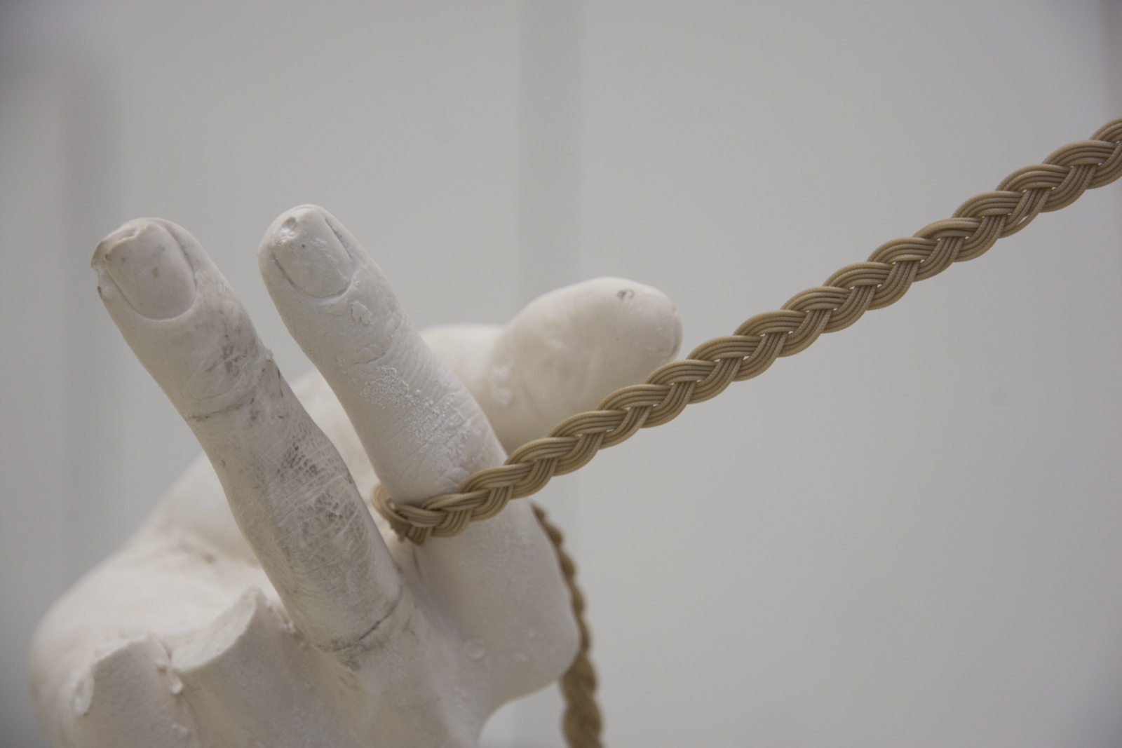 A close-up image of a plaster hand holding a braided kiteline. The plaster hand is missing the ring and pinky fingers. (because I accidentally dropped it oops)