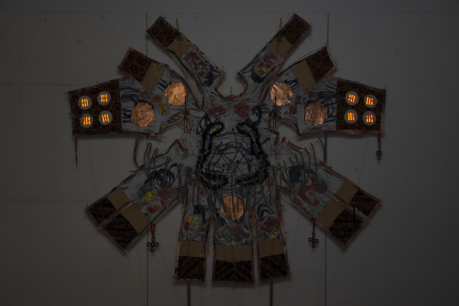 The kite is captured with a flash photo such that the copper foil and daoist bagua symbols glow.